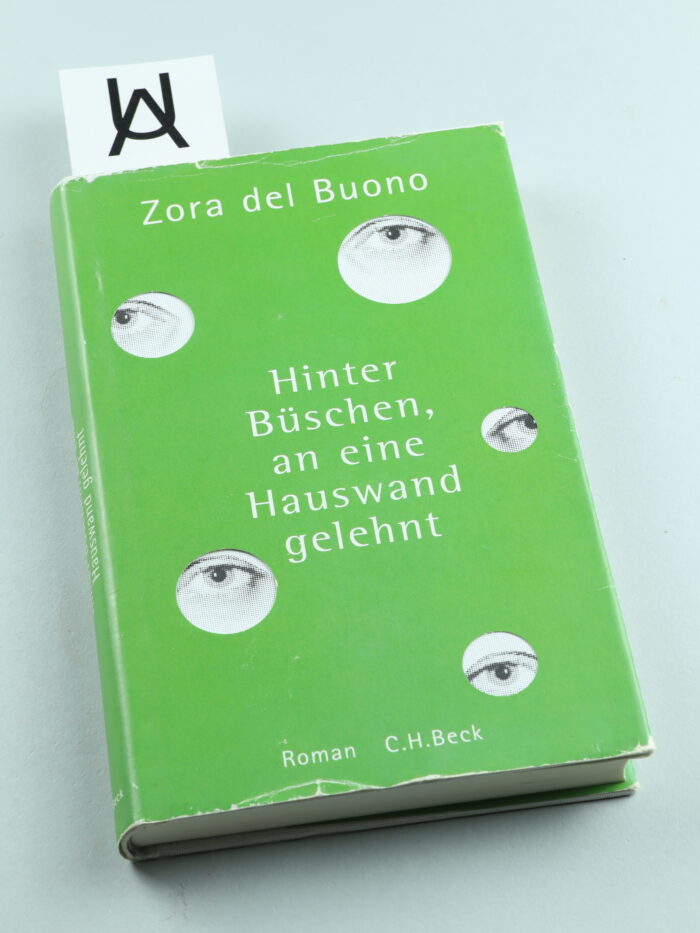 Hinter Büschen, an eine Hauswand gelehnt